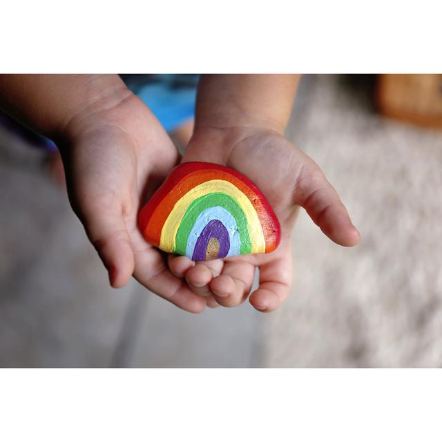 Child Holding Rainbow Rock - Wrapped Canvas Photograph Ebern Designs Size: 51cm H x 76cm W x 3.8cm D on Productcaster.