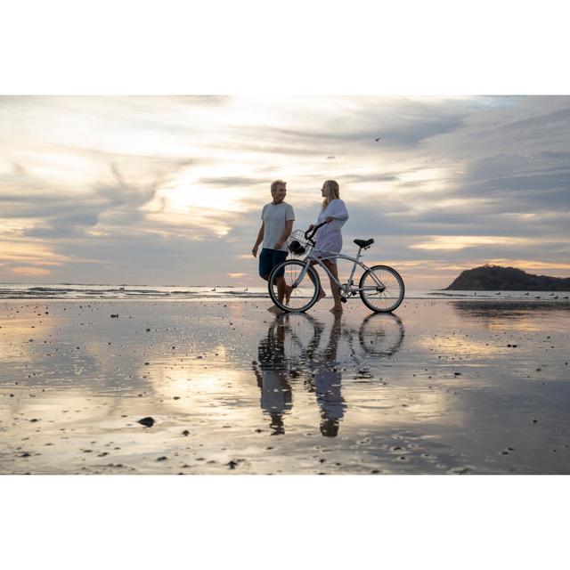 Mature Couple Push Bike Down Beach At Sunrise by AscentXmedia - No Frame Print on Canvas Wall Art Production Network Size: 61cm H x 91cm W on Productcaster.