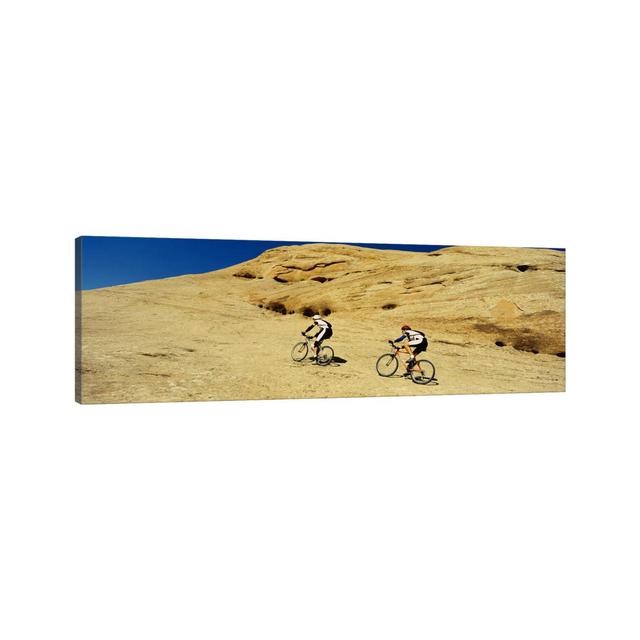 Side Profile Of Two Men Mountain Bilking On Rocks, Slickrock Trail, Moab, Utah, USA by Panoramic Images - Wrapped Canvas Panoramic Print Union Rustic on Productcaster.