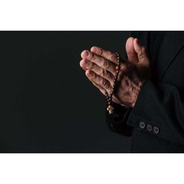 Hands of Priest Holding Rosary and Praying by Deandrobot - Wrapped Canvas Photograph Ebern Designs Size: 51cm H x 76cm W x 3.8cm D on Productcaster.