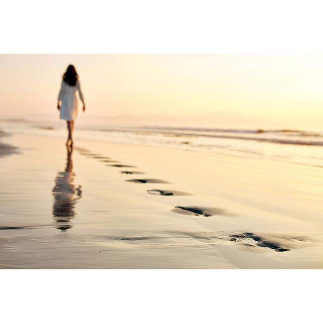 Woman Leaving Footprints by Neustockimages - No Frame Art Prints on Canvas Beachcrest Home Size: 81cm H x 122cm W on Productcaster.