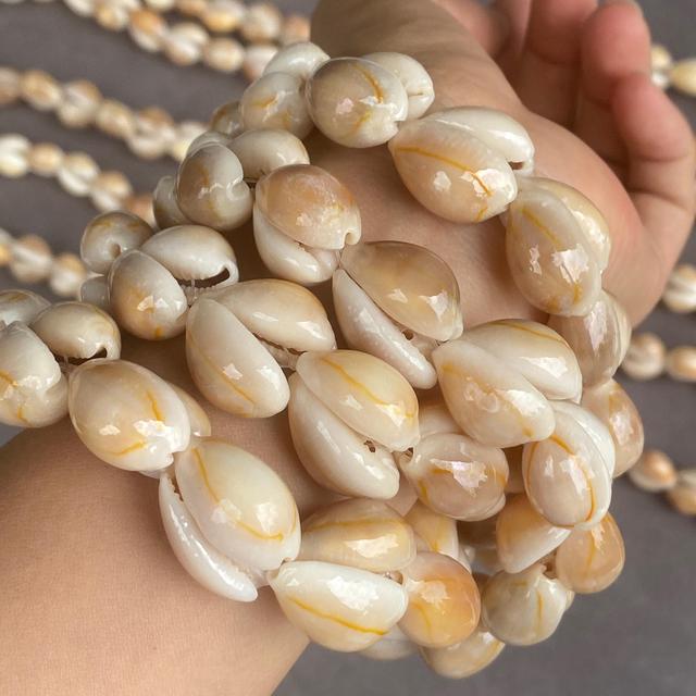 Gelbe Kauri Muschelperlen Strang für Schmuckherstellung im Boho Küstenstil mit natürlicher Maserung für kreative Designs on Productcaster.